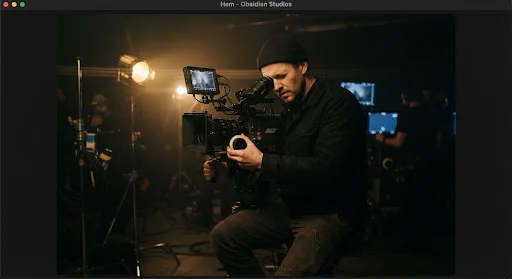 Filmfotograf vid kameran i ett mörkt produktionsrum — demobild